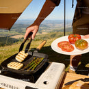 Grilling halloumi and asparagus outdoors with fresh tomatoes