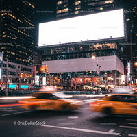 Busy urban intersection with blurred yellow taxis at night