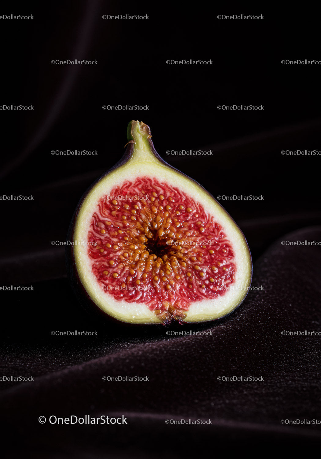 Close-up of ripe fig half on dark textured surface