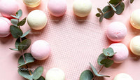 Delicate Pastel Macarons with Eucalyptus on Pink Background