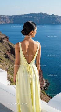 Woman in Yellow Dress Overlooking Blue Sea and Cliffs