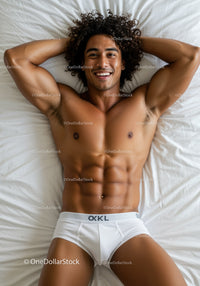 Smiling man relaxing on bed in white underwear