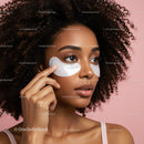 Close-up of a woman with curly hair applying a facial mask on her face