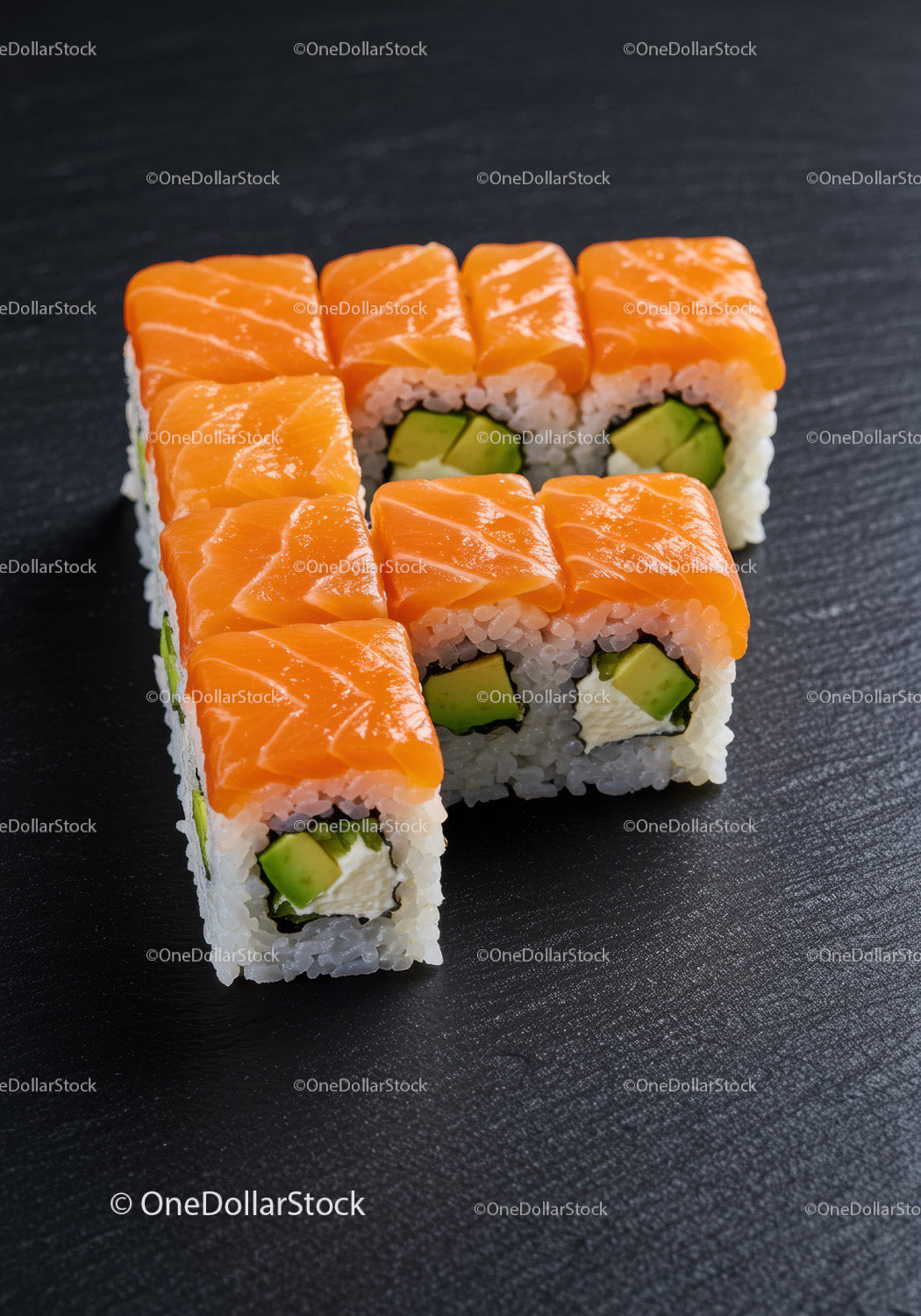 Świeże rolki sushi z łososiem i awokado na czarnym talerzu