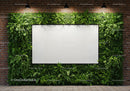 Modern blank whiteboard surrounded by lush greenery