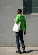 Young Man in Green Sweater and Jeans Carrying Tote Bag Outdoors