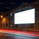 Illuminated blank billboard on brick building at night