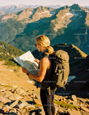 Hiker navigating mountain trails with detailed map