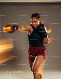Focused female boxer throwing a powerful punch in motion