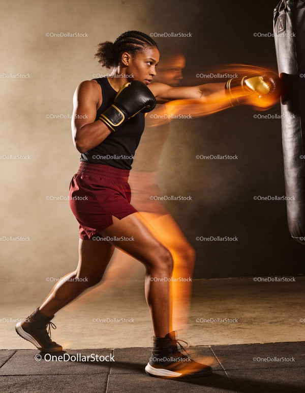 Focused female boxer training with intense punching motion