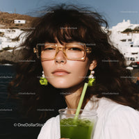 Fashionable Woman Wearing Sunglasses Drinking Green Cocktail Outdoors
