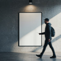 Man walking past blank illuminated poster on concrete wall