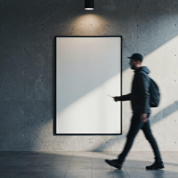 Man walking past blank illuminated poster on concrete wall JPG Mockup Image