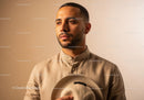 Elegant Man in Beige Shirt Holding Hat Against Neutral Background