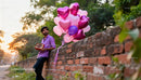 Young man with heart balloons and chocolates outdoors