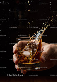 Hand Holding Glass of Whiskey with Splashing Ice Cubes