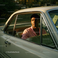 Young Man in Pink Shirt Sitting in Vintage Car on a Sunny Day