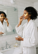 Elegant Woman Applying Under Eye Patches in Modern Bathroom