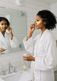 Elegant Woman Applying Under Eye Patches in Modern Bathroom