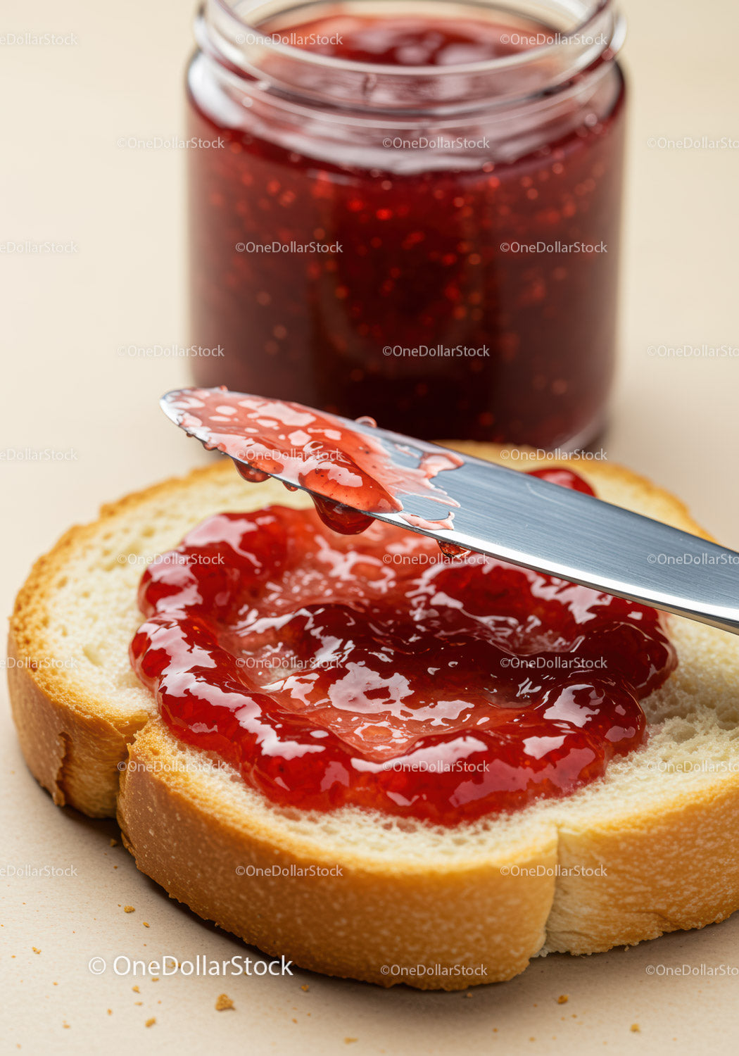 Fresh raspberry jam spread on soft white bread slice