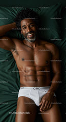 Smiling man resting relaxed on dark green bedding