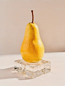 Fresh yellow pear on clear ice cube with beige background