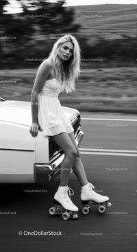 Blonde woman in white dress roller skating outdoors