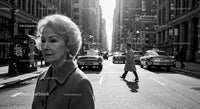 Elderly Woman in Busy City Street Surrounded by Vintage Cars