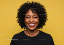 Vibrant Portrait of a Smiling Black Woman with Curly Hair on Yellow Background
