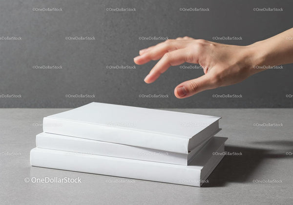 Hand about to pick a book from white stack JPG Mockup Image