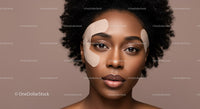Close-up of an African-American woman with facial patches for skincare treatment