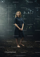 Barefoot woman standing thoughtfully in misty forest