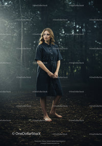 Barefoot woman standing thoughtfully in misty forest