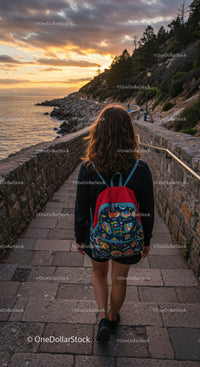 Young woman walking along scenic rocky coastline path