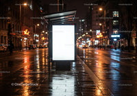 Nighttime Rainy City Street with Bus Stop Shelter and Bright Lights