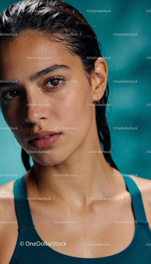 Focused young woman with wet hair after swimming workout