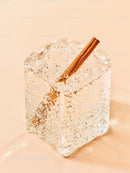 Close up of cinnamon stick frozen inside clear ice cube