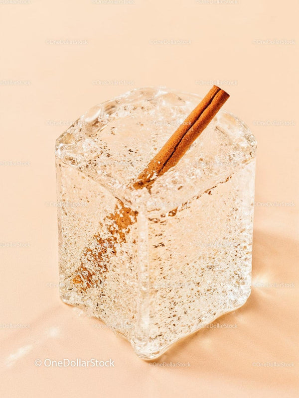 Close up of cinnamon stick frozen inside clear ice cube