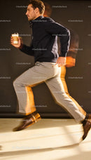 Man in blazer and trousers running with coffee cup