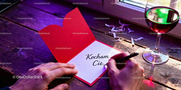 Writing a romantic love note on red heart card