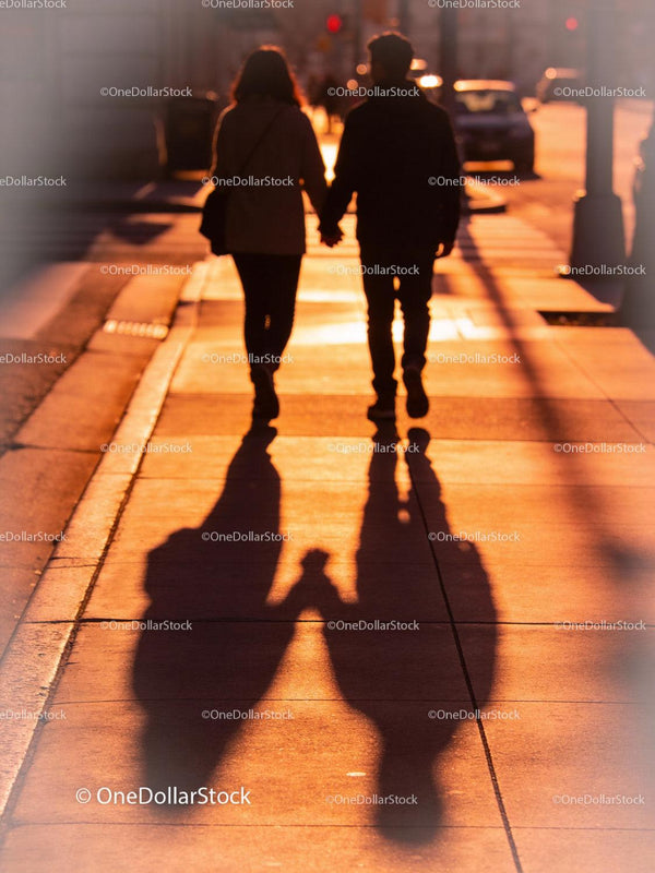 Couple Walking Hand in Hand in Warm Sunset Light