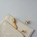 Baby hairbrush and pacifiers on quilted mat