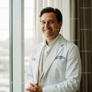 Smiling Doctor in White Coat in Bright Medical Facility