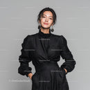 Elegant Woman in Black Leather Outfit Standing Against Gray Background