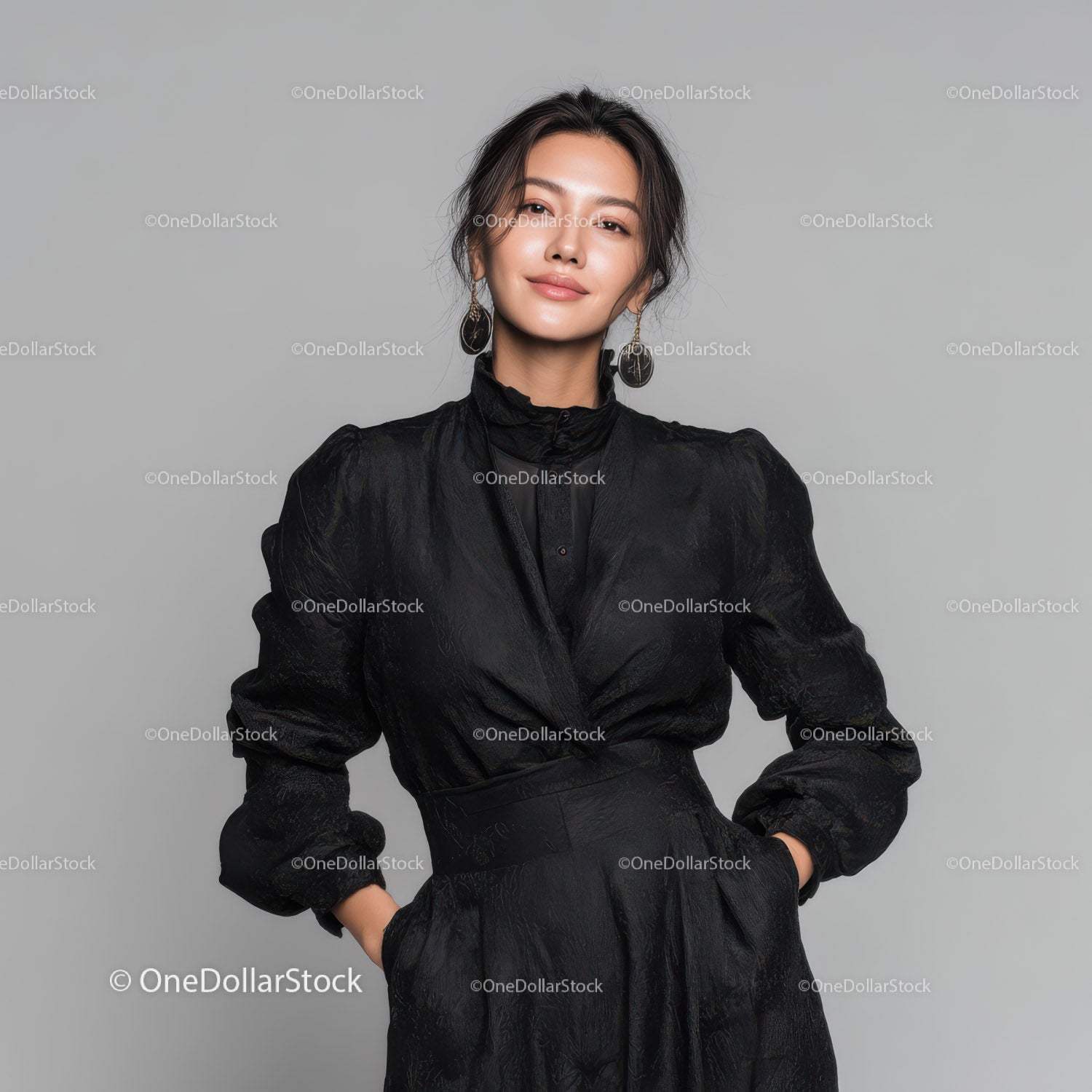 Elegant Woman in Black Leather Outfit Standing Against Gray Background