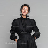 Elegant Woman in Black Leather Outfit Standing Against Gray Background