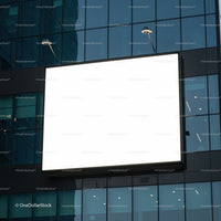 Blank illuminated billboard on modern glass building facade