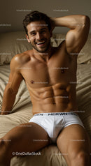Smiling muscular man relaxing on bed in white underwear
