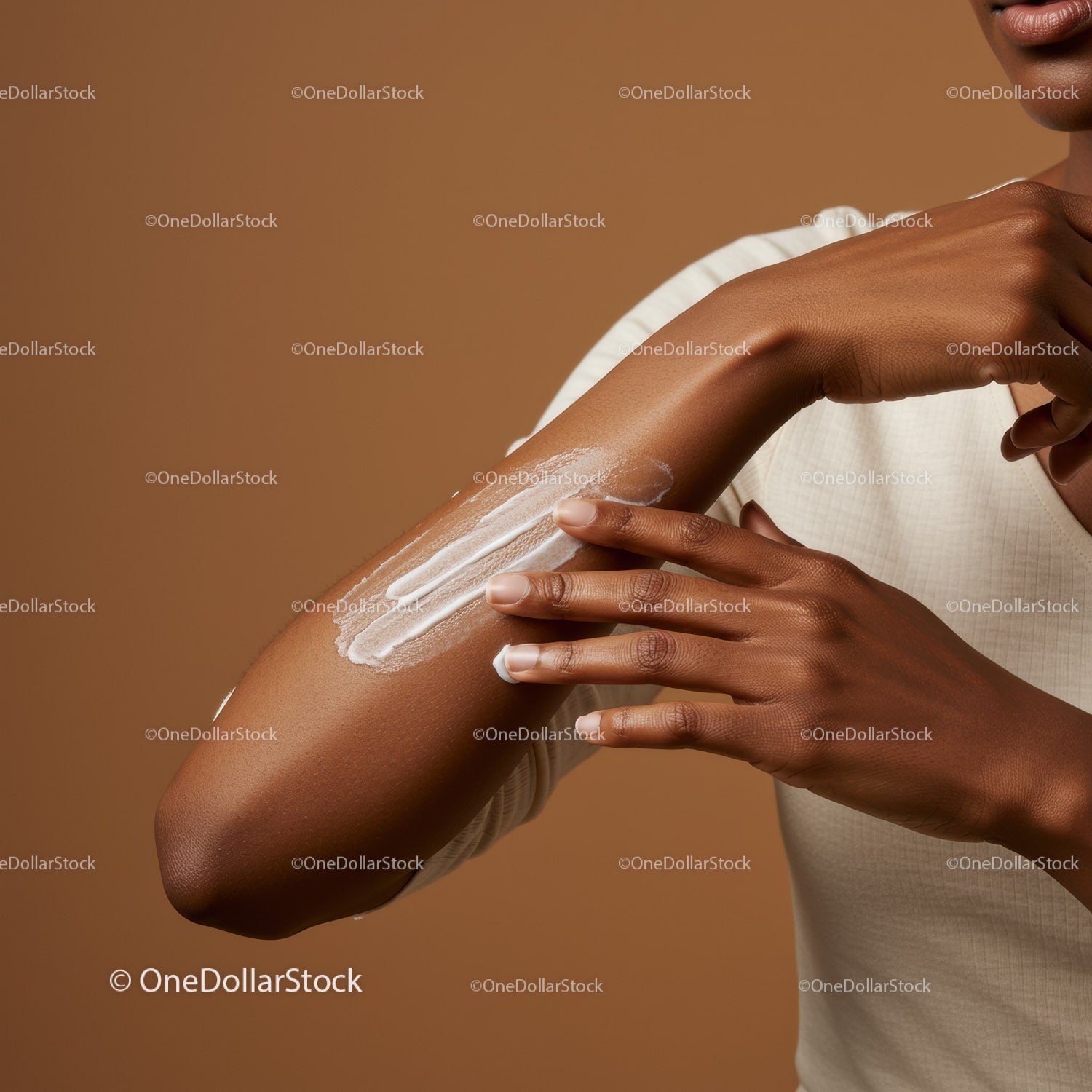 Close-up of a woman applying sunscreen lotion on her arm for skincare protection
