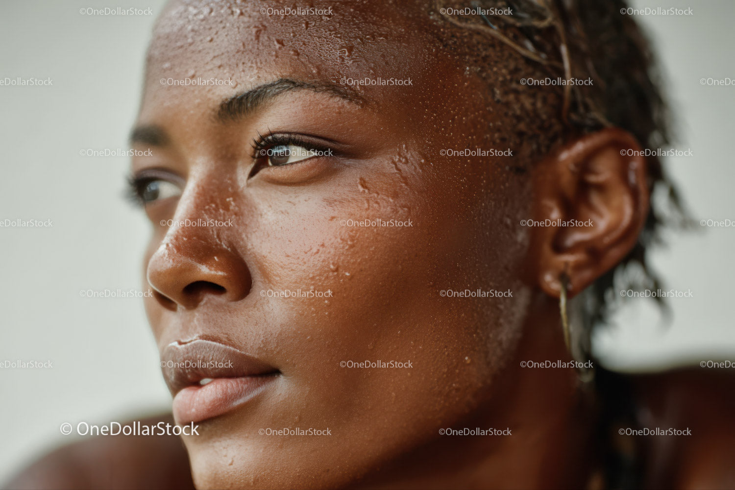 Close-up of a joyful woman with glowing skin and water droplets